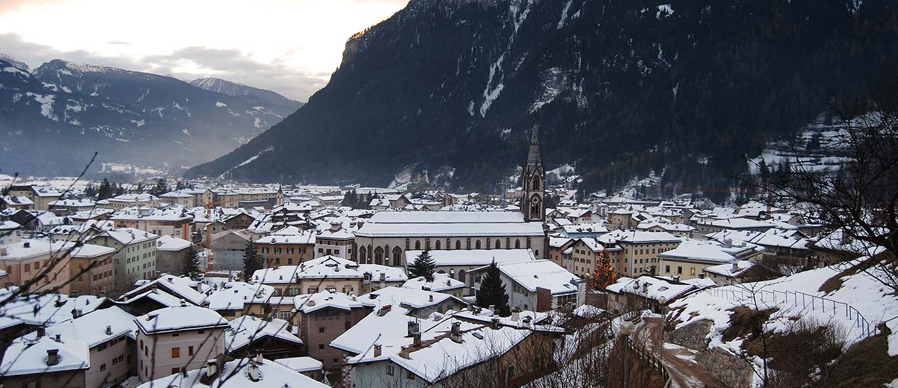 Ein Dorf in der Val di Fiemme im Winter mit Schnee bedeckten Dächern
