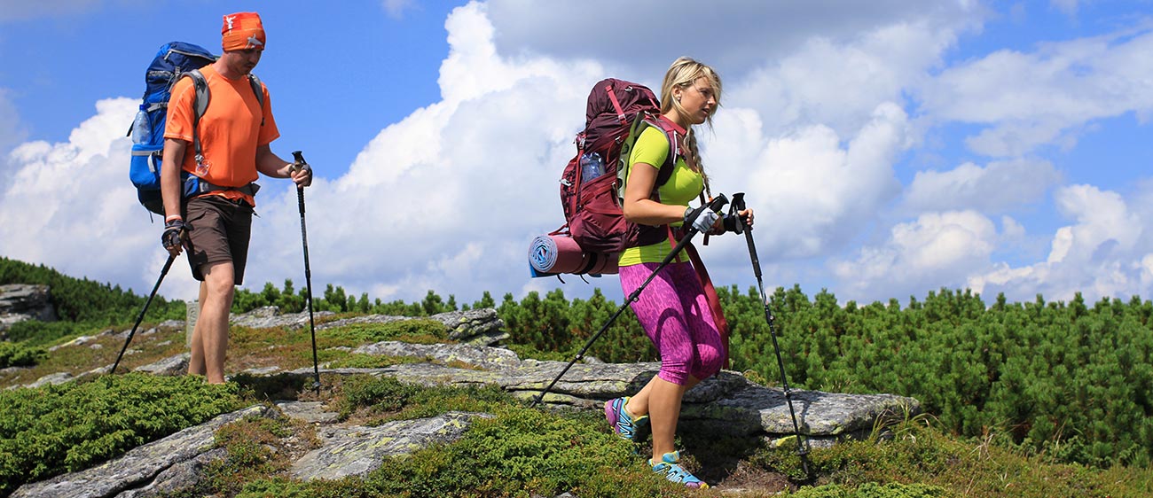 Due escursionisti camminano con i bastoni da Nordic Walking