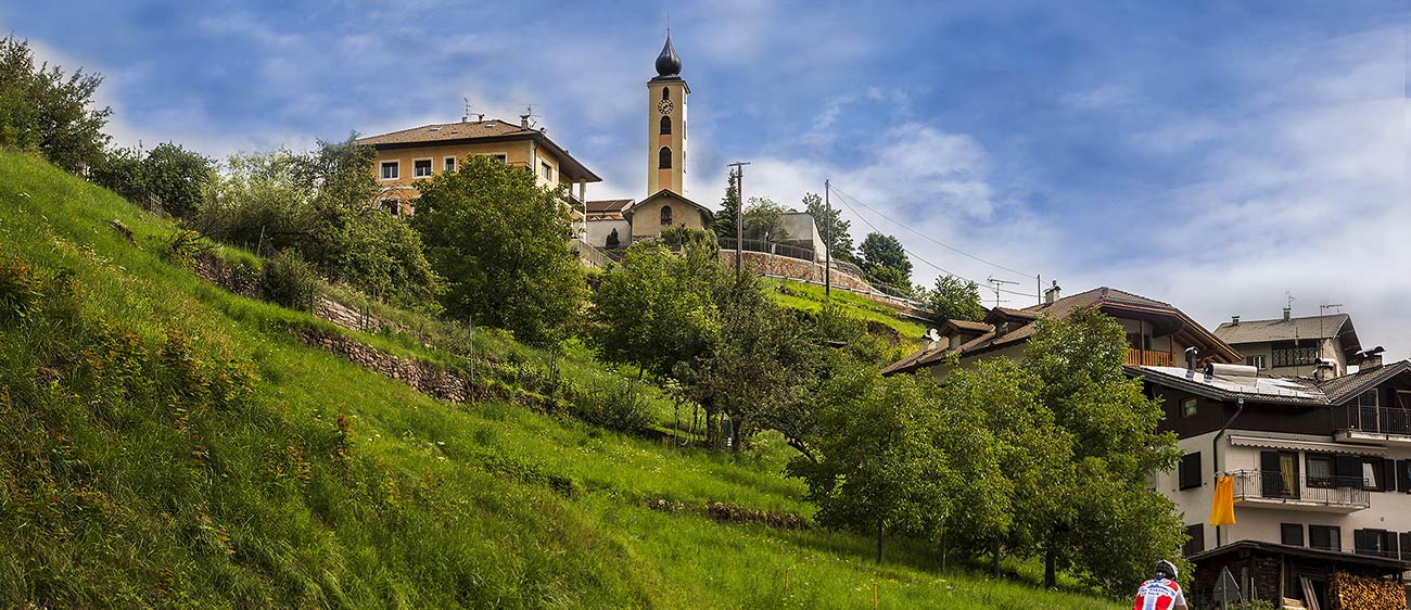 Vista dal basso al campanile del paese di Capriana