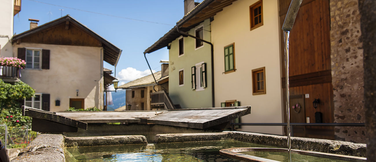 Ein Brunnen mit Wasserstelle umgeben von Häusern